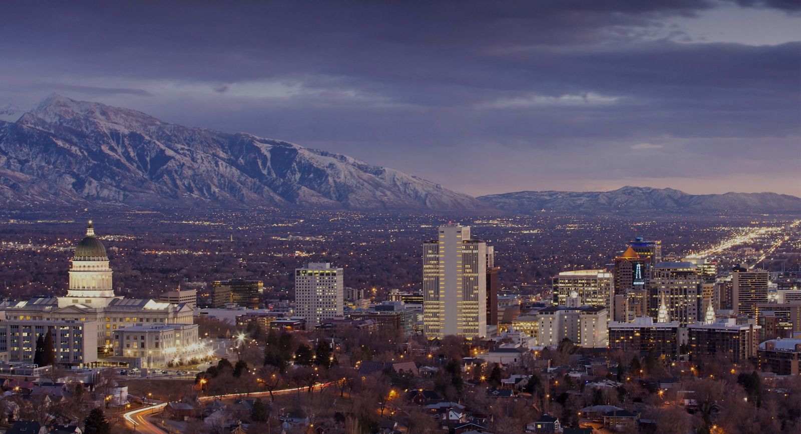 Salt Lake City skyline at dusk with the Wasatch Mountains